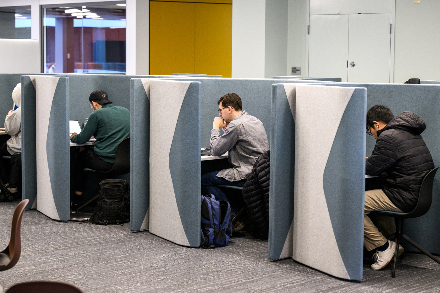 Picture of students studying in blue and white cubicles. 